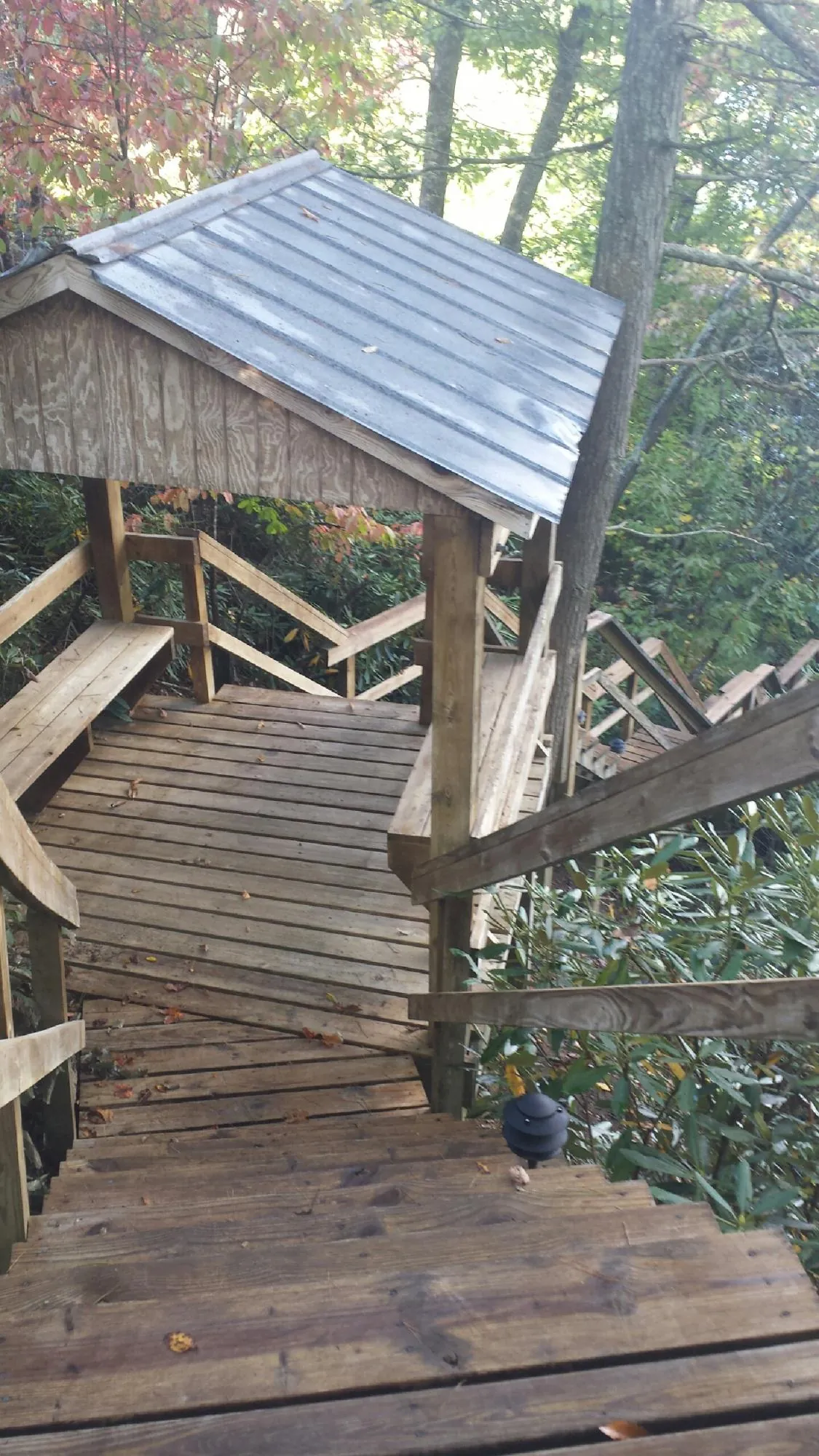 Metal roofed shelter over wooden steps on a wooded walkway — Skylight Repair & Installation work by our crew in Cos Cob