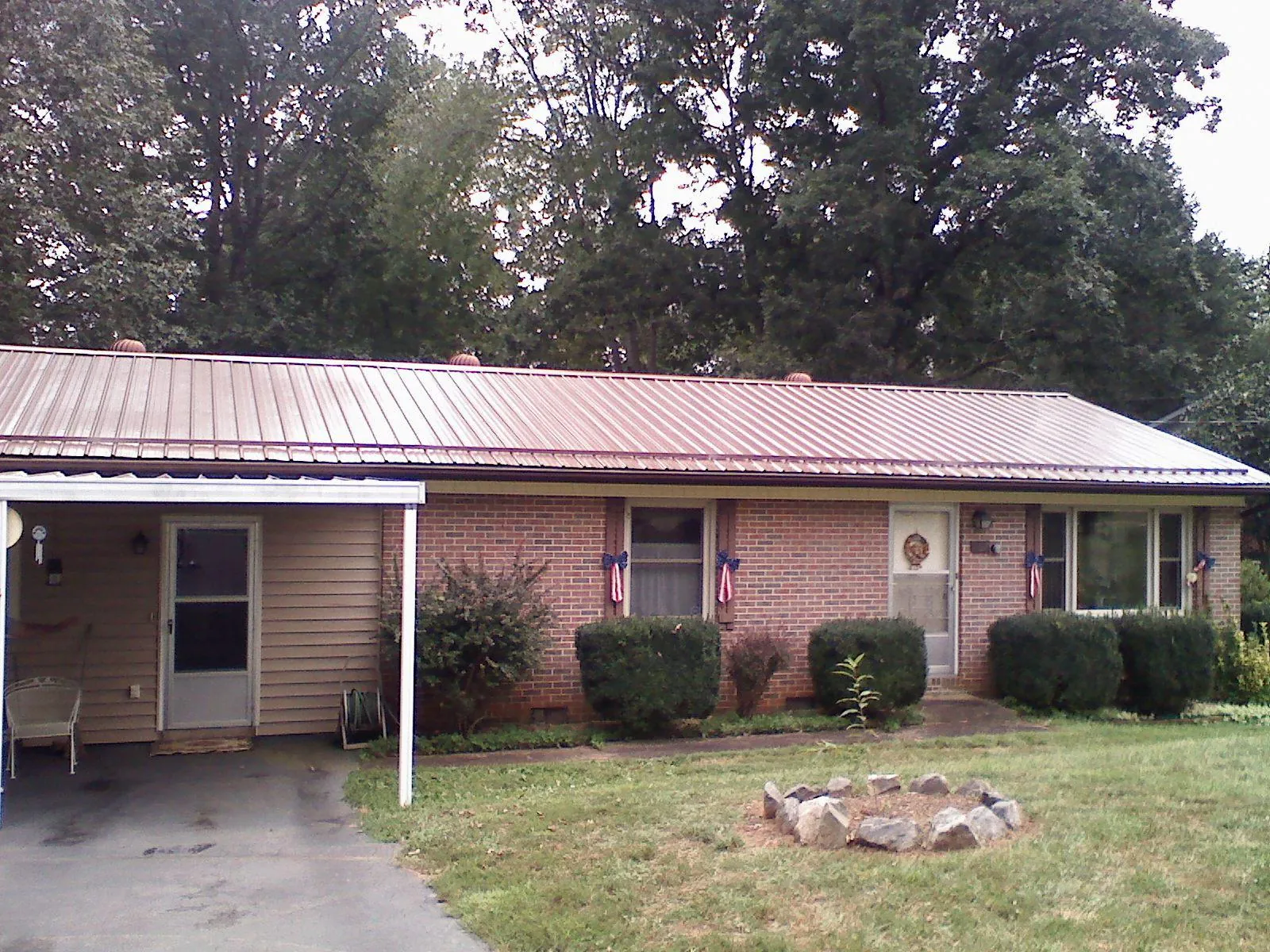 Bronze metal roof and carport on a brick ranch home — Roof Repair work by our crew in Cos Cob